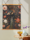 A wall tapestry featuring a detailed Victorian-style illustration of a peacock head with ornate feathers, surrounded by coral and white roses against a dark background, mounted on wooden dowels.